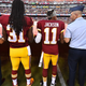 Washington Redskins players assist military personnel in holding the American flag.
Twitter